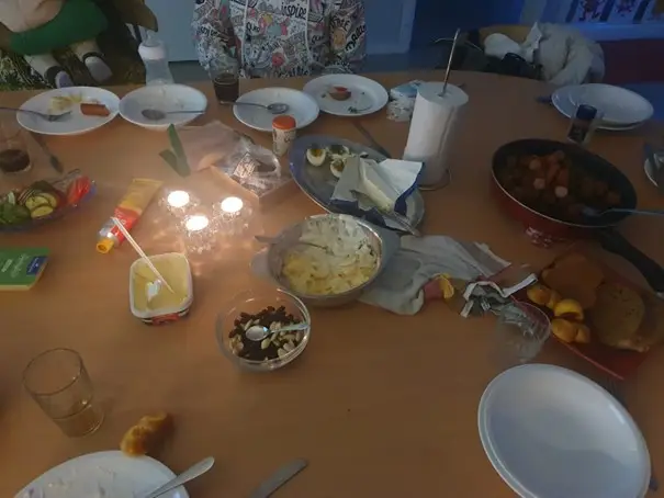 En grupp personer sitter på en gräsmatta.